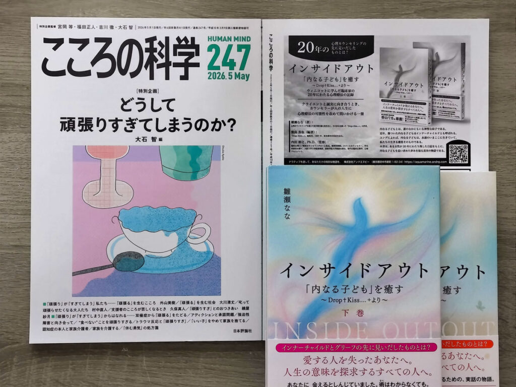 心理学専門誌『こころの科学』2026年5月号（通巻247号）と、掲載書籍『インサイドアウト 「内なる子ども」を癒す ～Drop+Kiss…+より～』上下巻の実物。誌面には本書の紹介ページが掲載されており、書籍の現物とともに掲載実績を確認できる。
